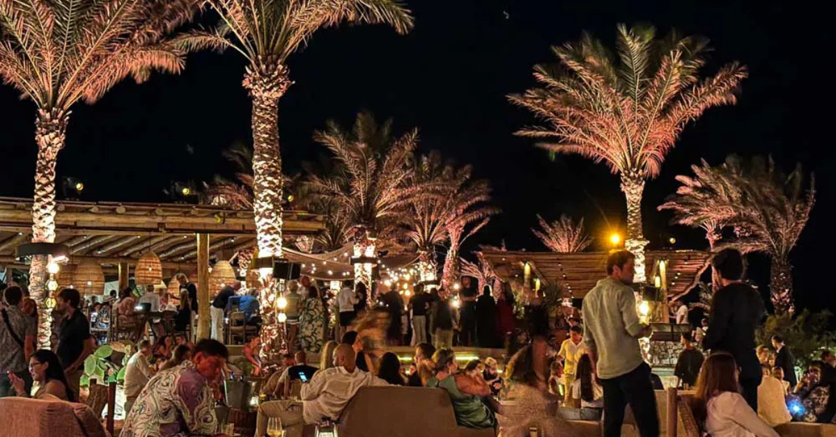 Guests enjoying front-row VIP tables at Scorpios Mykonos during sunset overlooking the Aegean Sea in Summer 2026.